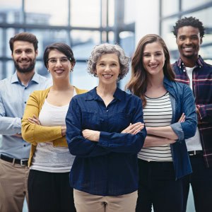 A diverse group of office workers standing together smiling