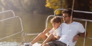 A father and son are sitting on a boat