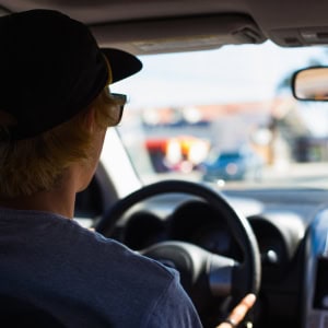 A teenager driving a car