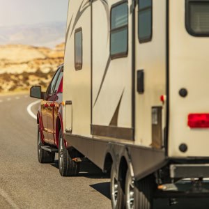 A travel trailer being pulled by a truck on the road