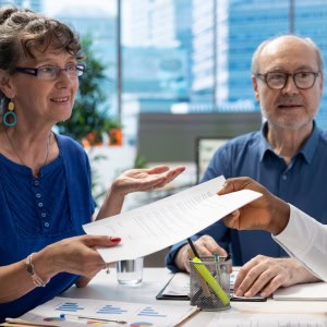 Mature couple discussing pension plans in an office