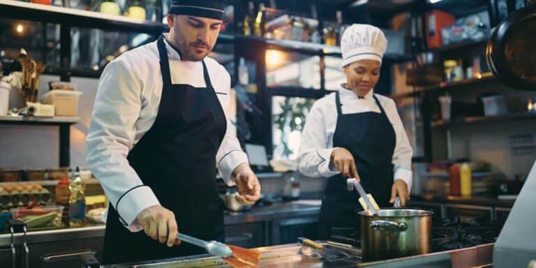 Two chefs cooking in a kitchen