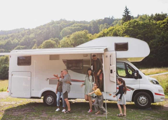 a multigenerational family is stepping out of their recreational vehicle