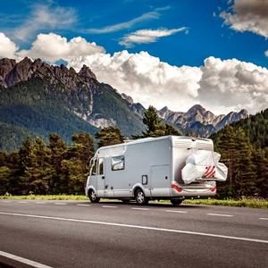 motorhome on road with mountains in background